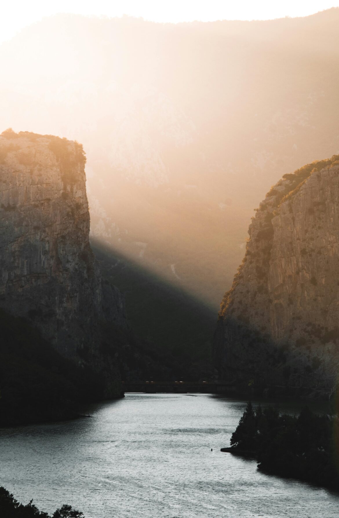 Stunning view of Shkopet Canyon during a golden sunset with dramatic cliffs and tranquil waters.