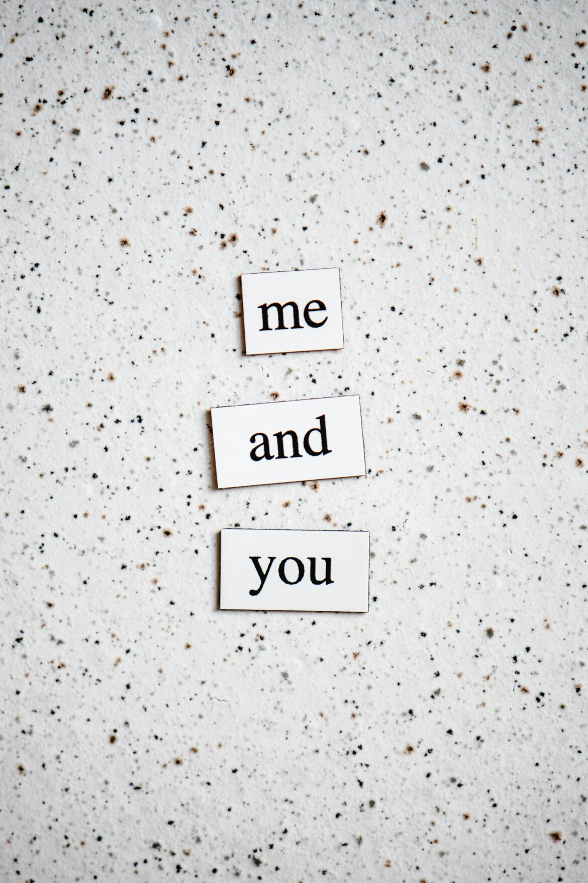 Simple words 'me and you' on speckled surface with minimalist typography.